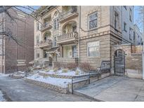 Multi-story brick apartment building with balconies, arched entryways, and landscaped front yard at 125 E 11Th Ave # 2, Denver, CO 80203