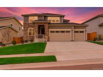 Charming two-story home with a stone facade, well-manicured lawn, and a spacious two car garage at 80 Back Nine Dr, Castle Pines, CO 80108