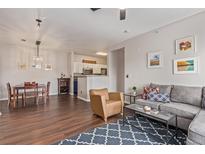 Cozy living room featuring hardwood floors, stylish furniture, and an open floor plan flowing to the kitchen at 4451 S Ammons St # 5-307, Littleton, CO 80123