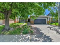 Charming one-story home featuring lush landscaping and a brick walkway leading to the front door at 11788 E Atlantic Pl, Aurora, CO 80014
