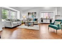 Bright living room with hardwood floors, stylish furniture, and a large window at 11788 E Atlantic Pl, Aurora, CO 80014