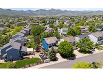 Scenic aerial view of a residential neighborhood with lush trees and mountain backdrop at 9569 Elk Mountain Cir, Littleton, CO 80125