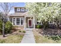 Charming two-story home with a well-maintained lawn, blossoming tree and inviting front porch at 17808 E 104Th Pl # C, Commerce City, CO 80022