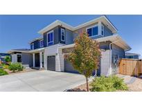 Beautiful two-story home featuring gray siding, white stone accents, and a three-car garage at 14290 Hop Clover St, Parker, CO 80134
