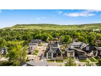 Beautiful aerial view of the neighborhood and custom homes, surrounded by lush trees and rolling hills at 3147 Juniper Ct, Golden, CO 80401