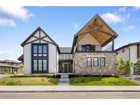 Stunning two-story home with a stone facade and modern architectural details in a manicured lawn at 3147 Juniper Ct, Golden, CO 80401