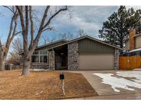 Charming home with stone accents, mature trees, and an attached two-car garage at 6066 S Monaco Way, Centennial, CO 80111