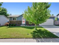 Charming single-story home with a well-manicured lawn, stone accents, and mature trees in a desirable neighborhood at 6074 S Dudley Way, Littleton, CO 80123
