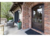 Charming brick home featuring an arched front door and a cozy front patio seating area at 2260 S Jackson St, Denver, CO 80210