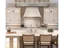 Gourmet kitchen features custom cabinets, marble backsplash, and professional-grade appliances at 2260 S Jackson St, Denver, CO 80210