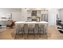 Bright kitchen boasts a large island with bar seating and stainless steel appliances at 1256 Xavier St, Denver, CO 80204