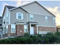Two-story home featuring stone accents, neutral siding, and a covered front entry in a well-maintained landscape at 12766 Jasmine St # F, Thornton, CO 80602