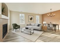 Bright living room featuring a modern sofa, stylish coffee table, fireplace, and dining area with contemporary lighting at 12766 Jasmine St # F, Thornton, CO 80602