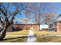 Charming brick home with a well-maintained front yard and mature trees at 1421 Jasmine St # 1, Denver, CO 80220