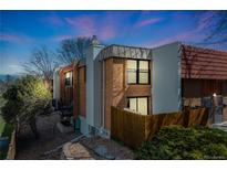 Charming brick townhome exterior with balconies, chimney and mature landscaping, set against a twilight sky at 2917 S Locust St, Denver, CO 80222