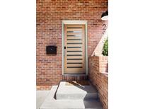 Inviting front door with horizontal windows and a brick exterior, creating a warm and stylish entrance at 2931 W 20Th Ave, Denver, CO 80211