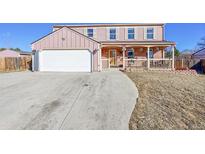 Charming two-story home featuring a front porch, two car garage, and a spacious driveway at 2518 S Ouray Way, Aurora, CO 80013