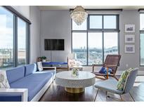 Bright living room featuring hardwood floors, modern furnishings, and large windows for ample natural light at 3100 Huron St # 2D, Denver, CO 80202