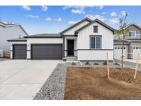 Charming home with a two car garage, newly laid gravel, and manicured front yard landscaping at 14390 Heritage Dr, Mead, CO 80504