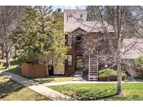 Charming townhome with a cozy front entrance, a lush lawn, and mature trees at 6251 Willow Ln, Boulder, CO 80301