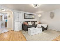 Cozy living room featuring a gray sofa, coffee table, and hardwood floors at 3826 N Vrain St # 5, Denver, CO 80212