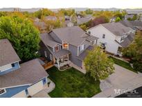 Aerial view of two-story house with gray siding, three-car garage, and landscaped yard at 2973 E 135Th Way, Thornton, CO 80241