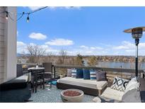 Relaxing rooftop deck with plush seating, fire pit, and panoramic views of the lake and blue skies at 4072 W 17Th Ave, Denver, CO 80204