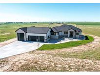 Stunning home with a sprawling driveway and a three-car garage, set against a serene landscape at 56520 E 74Th Ave, Strasburg, CO 80136