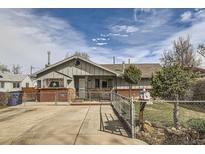 A charming one-story home with a fenced yard, inviting curb appeal, and driveway at 828 S Osceola St, Denver, CO 80219