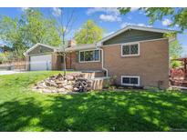 Charming brick home with lush green lawn and rock garden in front at 1522 Utah St, Golden, CO 80401