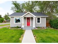 Charming home with gray siding, a red front door, and a well-manicured lawn at 4406 S Delaware St, Englewood, CO 80110