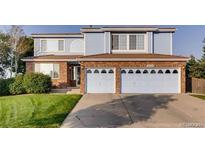 Two-story house with brick and blue siding, three-car garage, and landscaped lawn at 20102 E 43Rd Ave, Denver, CO 80249