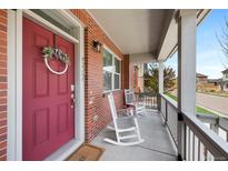 Inviting covered porch with rocking chairs and brick facade at 5404 W 95Th Pl, Westminster, CO 80020