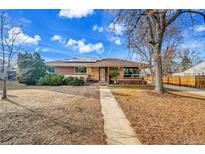 Charming single-story home with a well-manicured lawn, a walkway, and solar panels on the roof at 435 Cody Dr, Lakewood, CO 80226