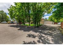 Spacious driveway with mature trees and view of garage and two-story home at 3525 S Brentwood St, Lakewood, CO 80235