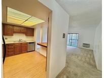Bright kitchen featuring wood cabinets, stainless steel appliances, and an opening to the carpeted living room at 13992 E Marina Dr # 303, Aurora, CO 80014