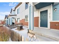 Charming townhome exterior with red brick accents and a cozy front patio area with fire pit at 2162 Tamarac St, Denver, CO 80238