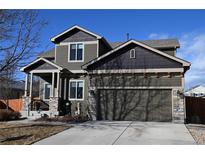 Charming two-story home with an attached garage, stone accents and well-maintained landscaping at 9121 Harlequin Cir, Frederick, CO 80504