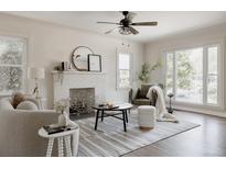 Bright living room featuring a fireplace, modern furnishings, and large windows that let in plenty of natural light at 3055 Clermont St, Denver, CO 80207