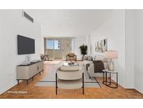 Bright living room with hardwood floors and sliding glass door access to a balcony at 1250 N Humboldt St # 1002, Denver, CO 80218