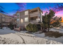 Evening view of a three-story townhouse with snow on the ground at 12912 Ironstone Way # 101, Parker, CO 80134