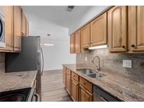 Updated kitchen features granite countertops, stainless steel appliances and wood cabinets at 7755 E Quincy Ave # 308A5, Denver, CO 80237