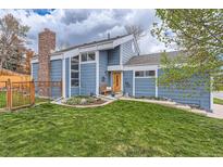 Inviting home featuring a charming front yard, brick chimney, and attractive light-blue siding at 10743 W Berry Pl, Littleton, CO 80127