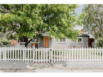 Charming home featuring a well-manicured lawn, a welcoming white picket fence and mature trees for added privacy at 1200 S Patton Ct, Denver, CO 80219