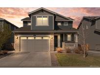 Charming two-story home featuring stone accents, gray siding, a two-car garage, and a well-manicured front yard at 455 N Old Hammer St, Aurora, CO 80018