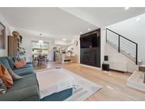 Bright living room features a fireplace, television, and an open floor plan leading to dining area and the kitchen at 9400 E Iliff Ave # 145, Denver, CO 80231