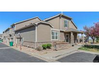 Charming townhome featuring stone accents, well-maintained landscaping, and an attached one car garage at 4739 Raven Run, Broomfield, CO 80023