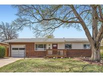 Charming single-story brick home with a well-manicured front lawn and inviting wooden porch at 2201 S Lowell Blvd, Denver, CO 80219