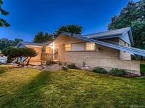 Well-maintained brick home featuring a green lawn and mature landscaping at 1145 W 101St Ave, Northglenn, CO 80260