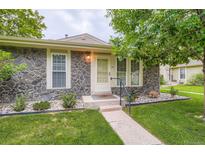 Charming single-Gathering home featuring a stone facade and a well-manicured front yard with mature landscaping at 1250 S Monaco Street Pkwy # 49, Denver, CO 80224